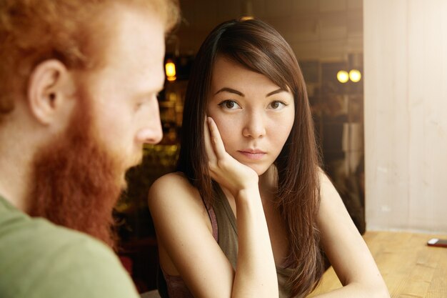 Brunetka kobieta i imbir mężczyzna siedzi w kawiarni
