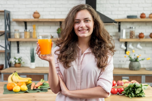 Brunetka kobieta pije sok pomarańczowy