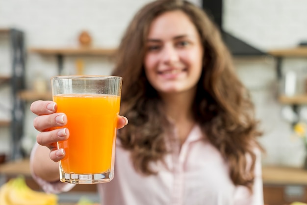 Bezpłatne zdjęcie brunetka kobieta pije sok pomarańczowy