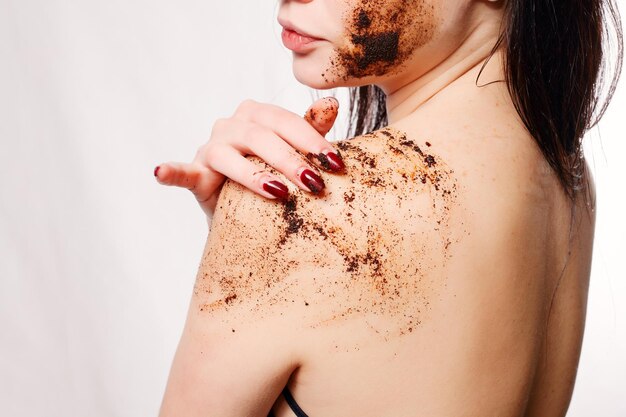 Brunetka oczyszcza skórę ciała kawowy peeling