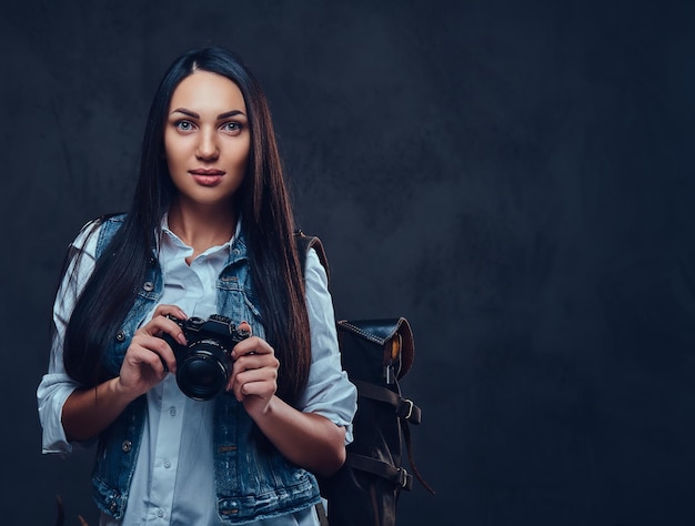 Brunetka Podróżniczka Z Plecakiem Trzyma Kompaktowy Aparat Fotograficzny.