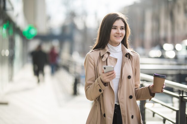 Brunetki kobiety model pije kawę wśrodku dużego centrum handlowego