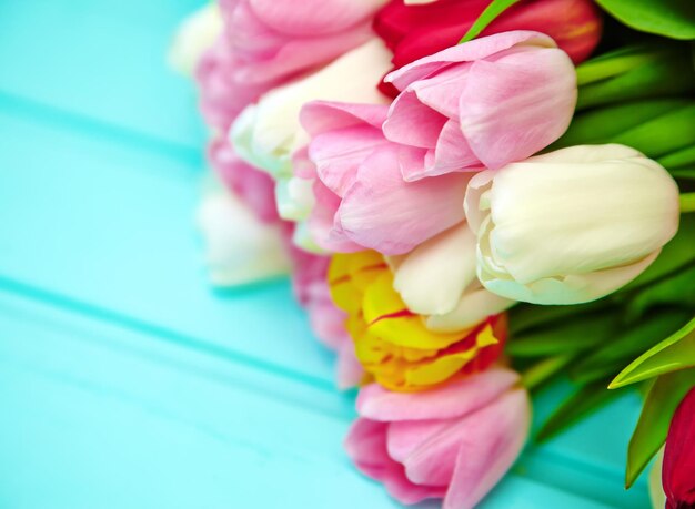 Bukiet świeżych wielokolorowych kwiatów tulipanów na starym niebieskim drewnianym stole