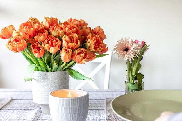 Bukiet tulipanów i świeca na stole z bliska