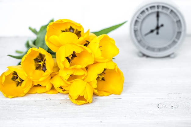 Bukiet żółtych tulipanów i zegar retro