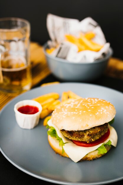 Burger z bliska z dużym frytkami na talerzu