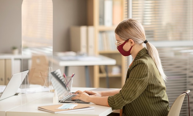 Businesswoman nosząc maskę w biurze