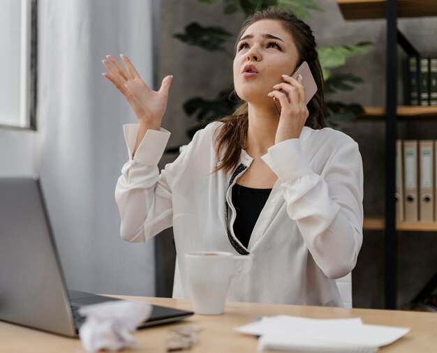 Businesswoman patrząc sfrustrowany, mając połączenie