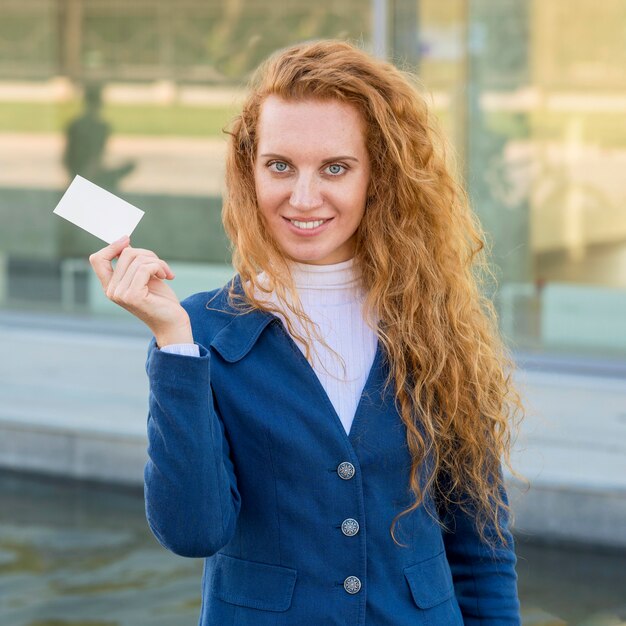 Businesswoman trzyma wizytówkę średnio strzał