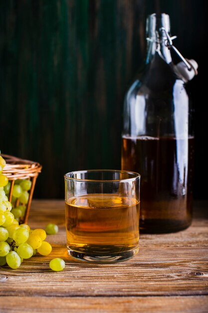 Butelka i szkło na stole z sokiem ze świeżych winogron