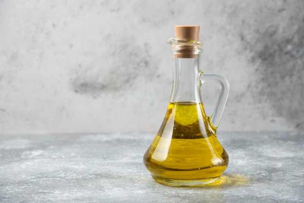 Butelka oliwy z oliwek na marmurowym stole.