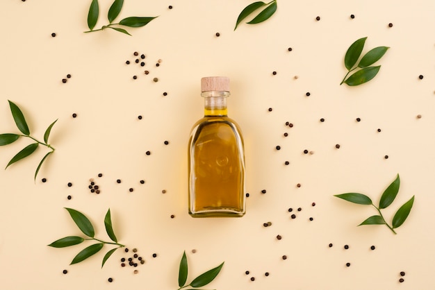 Butelka oliwy z oliwek otoczona liśćmi oliwnymi