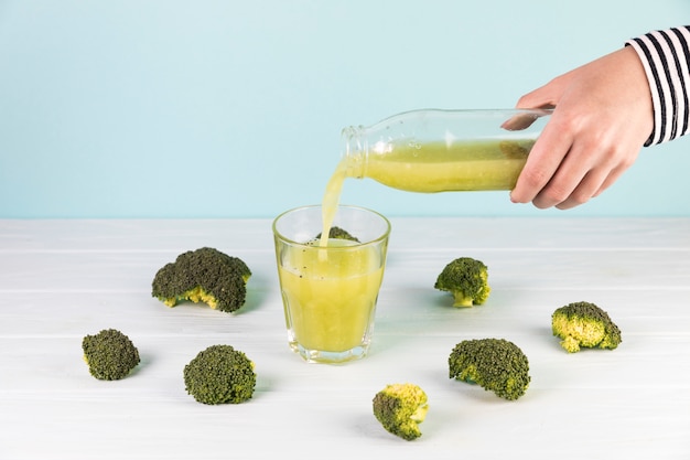 Bezpłatne zdjęcie butelka świeżego smoothie brokułów wlewa się do szklanki
