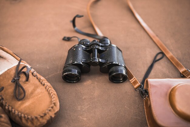 Buty i torba na aparat fotograficzny w pobliżu lornetki