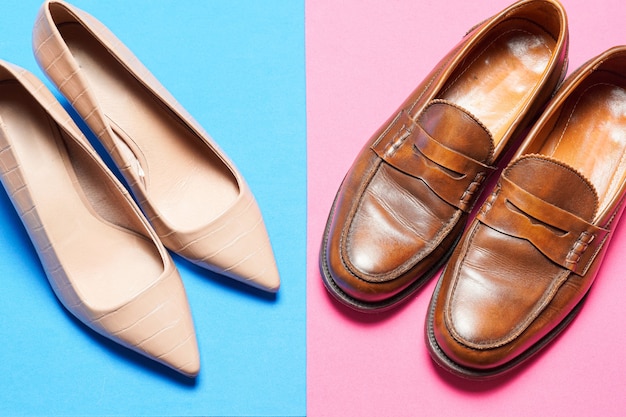 Buty męskie i damskie na niebiesko-różowym kolorowym tle. biznesowe buty robocze z miejsca kopiowania płaskie leżał. widok z góry