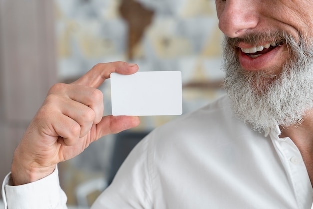 Buźka starszy mężczyzna trzymający wizytówkę