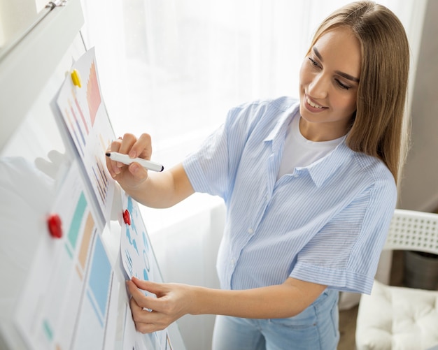 Buźka w ciąży bizneswoman daje prezentację w biurze przy użyciu tablicy