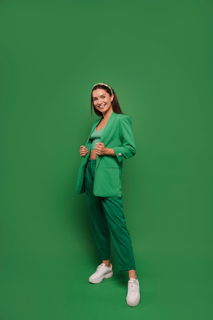 Bezpłatne zdjęcie cała kobieta pozująca w zielonym stroju
