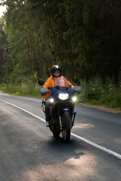 Całkowite ujęcie chłodnej starej kobiety na motocyklu.