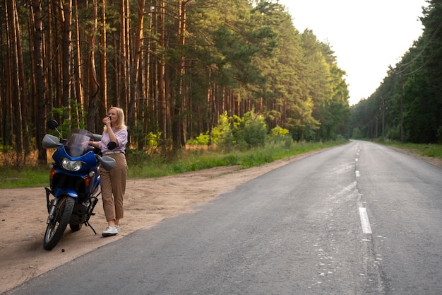 Bezpłatne zdjęcie całkowite ujęcie chłodnej starej kobiety na motocyklu.