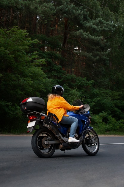 Całkowite ujęcie chłodnej starej kobiety na motocyklu.