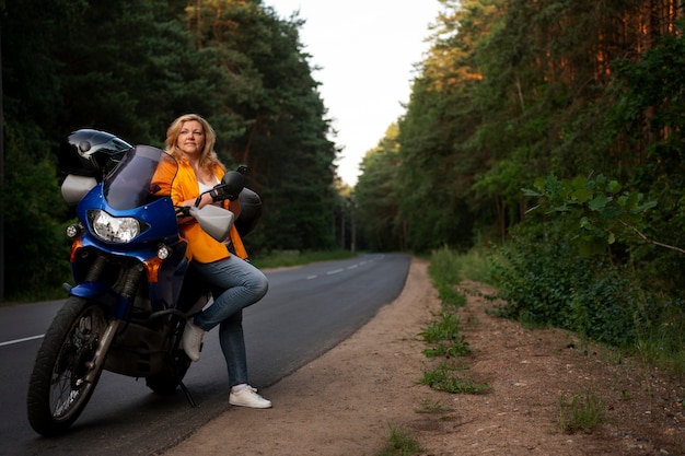 Bezpłatne zdjęcie całkowite ujęcie chłodnej starej kobiety na motocyklu.