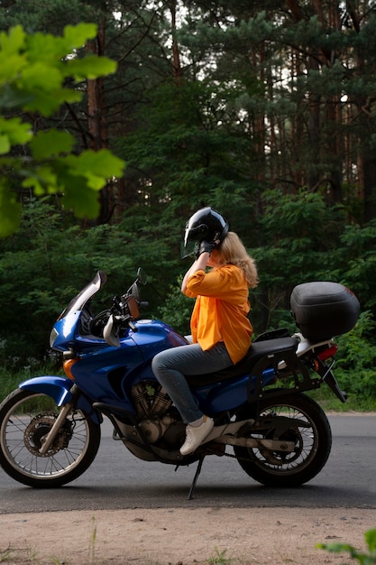 Całkowite ujęcie chłodnej starej kobiety na motocyklu.