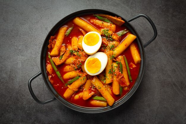 Cheesy Tokbokki koreańskie tradycyjne potrawy na tle czarnej tablicy. Danie na lunch.