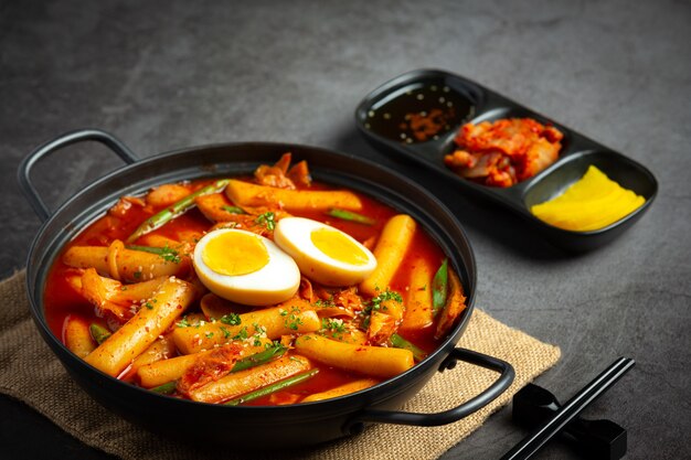 Cheesy Tokbokki koreańskie tradycyjne potrawy na tle czarnej tablicy. Danie na lunch.