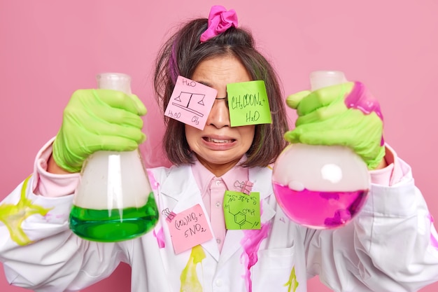 Bezpłatne zdjęcie chemik zdenerwowany nieudanym eksperymentem pracuje w nowoczesnym laboratorium lub ośrodku badawczym nad odrzuceniem szczepionki przeciwko pandemii covid 19 ma na oczach naklejki z wzorami chemicznymi