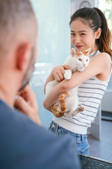 Chińska młoda kobieta trzyma jej domowego kota i bierze dba. styl życia miłośników zwierząt.