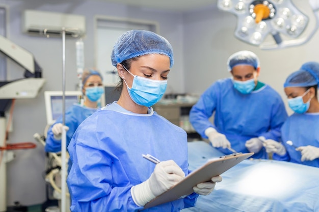 Chirurg piszący w schowku w sali operacyjnej anestezjolog piszący aktualizacje