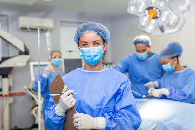 Bezpłatne zdjęcie chirurg piszący w schowku w sali operacyjnej anestezjolog piszący aktualizacje