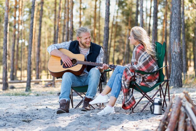 Chłopak gra na gitarze akustycznej dla swojej dziewczyny