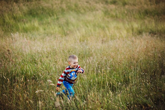 Chłopiec biega na zieleni polu