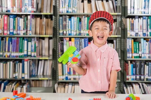 Chłopiec gra z bloków z tworzywa sztucznego w pokoju biblioteki pokoju