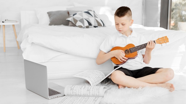 Chłopiec Ogląda Samouczki Online Dotyczące Gry Na Ukulele