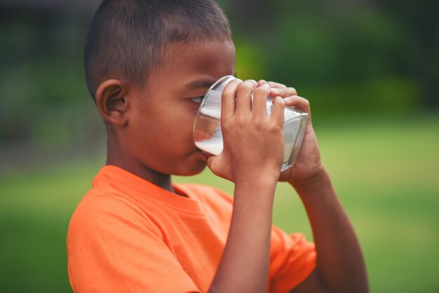 Chłopiec pije mleko w parku