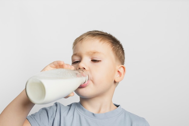 Chłopiec pije mleko z butelką