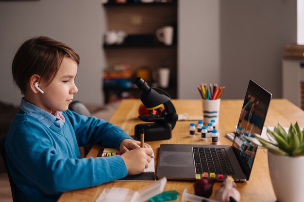 Chłopiec Preteen używa laptopa do rozmowy wideo ze swoim nauczycielem