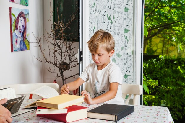Chłopiec przy biurku z książkami