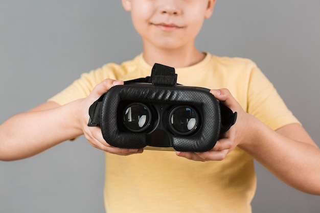 Chłopiec trzyma słuchawki wirtualnej rzeczywistości