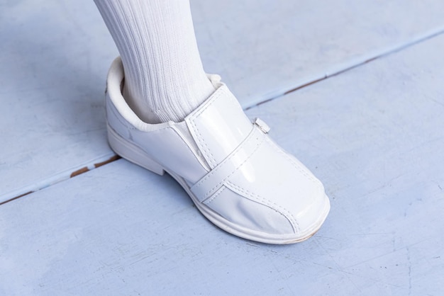 Bezpłatne zdjęcie chłopiec w białych butach kroczący po podłodze