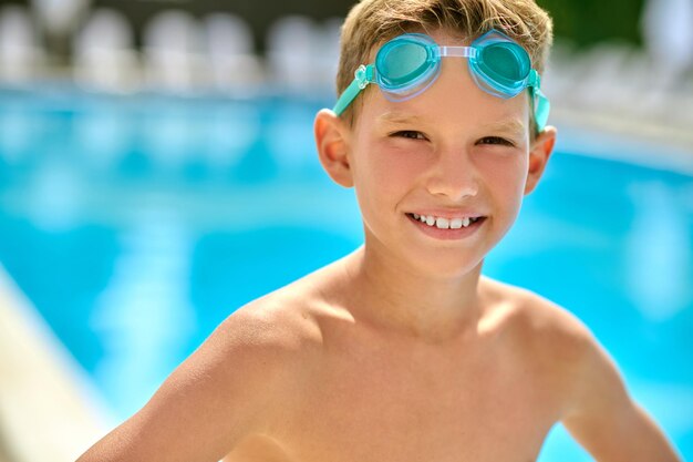 Chłopiec w okularach pływackich patrzący w kamerę