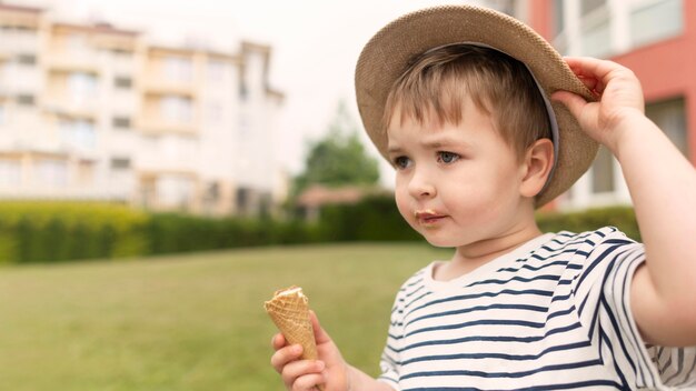 Chłopiec z kapeluszem cieszy się lody