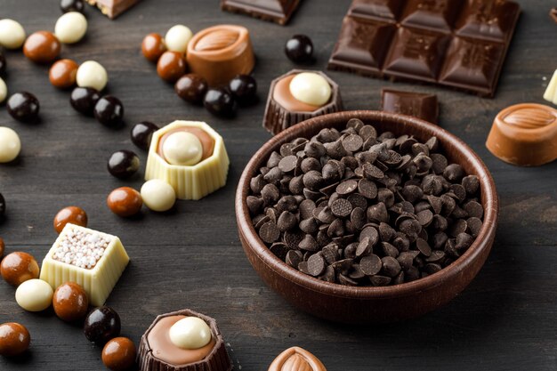 Choco spada z chocoballs, batonami choco i karmelem w glinianej misce na drewnianym stole