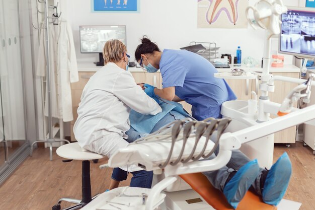 Chory mężczyzna siedzący na fotelu dentystycznym podczas badania lekarskiego