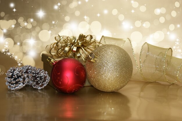 Christmas gift i bombki na złotym tle rozgwieżdżonego