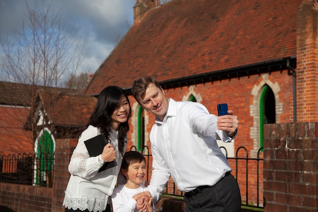 Chrześcijańska rodzina w średnim ujęciu robi selfie