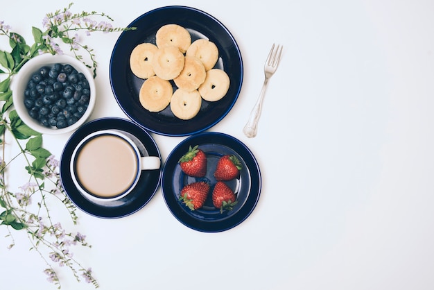 Bezpłatne zdjęcie ciasteczka; jagody; kawa i truskawki na białym tle